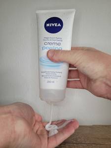 Peeling-Creme wird aus Tube gequetscht