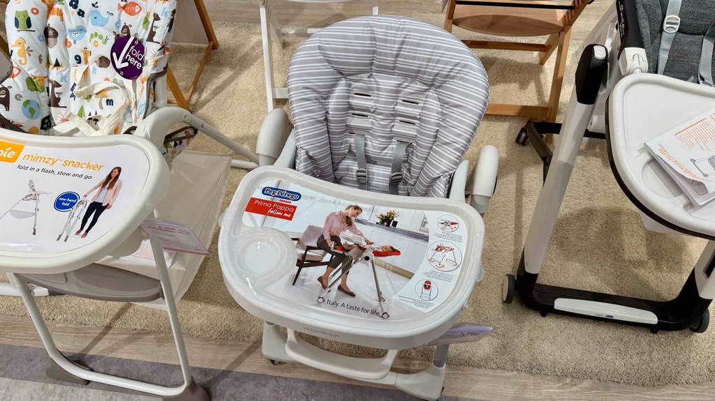 Ein getesteter Baby-Hochstuhl mit Liegefunktion steht von oben betrachtet zwischen weiteren Baby-Hochstühlen.