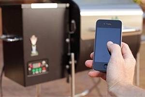 Mit einem Smartphone wird ein Funk-Test Pelletgrill durchgeführt.