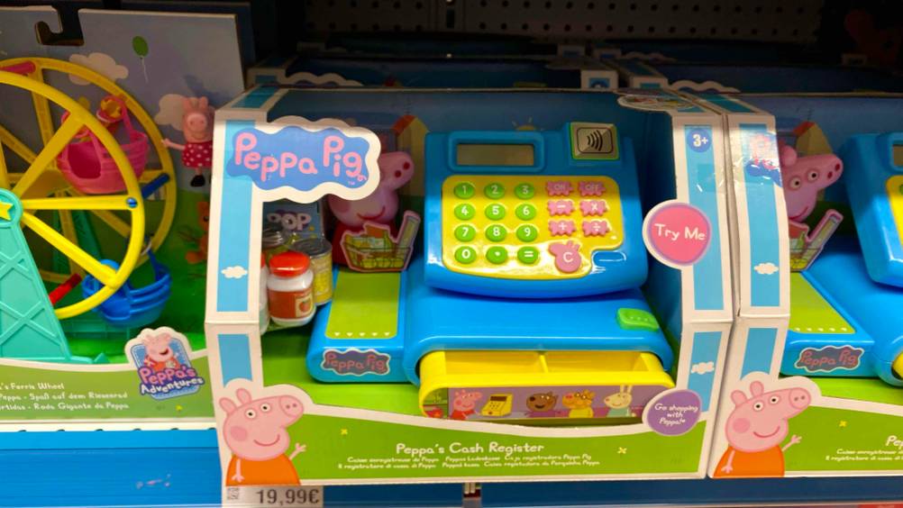 In einem Verkaufsregal befindet sich eine getestete Kaufladen-Kasse der Marke Peppa Pig.