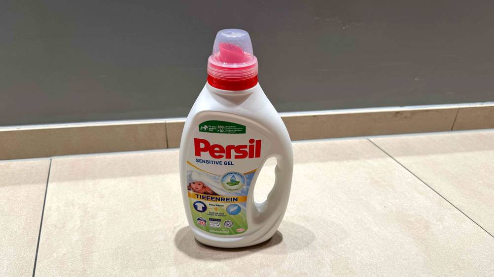 Auf einem hellen Boden steht eine Flasche des getesteten Persil-Waschmittels.