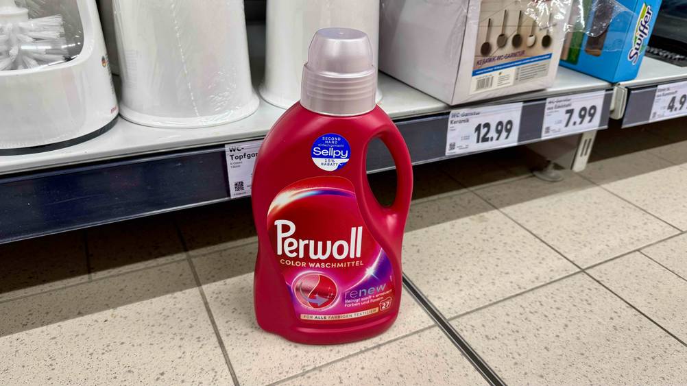 Eine Flasche des getesteten Perwoll-Flüssigwaschmittels steht vor einem Verkaufsregal auf dem Boden.
