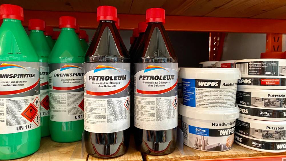 Mehrere Flaschen mit getestetem Petroleum stehen in einem Geschäftsregal.