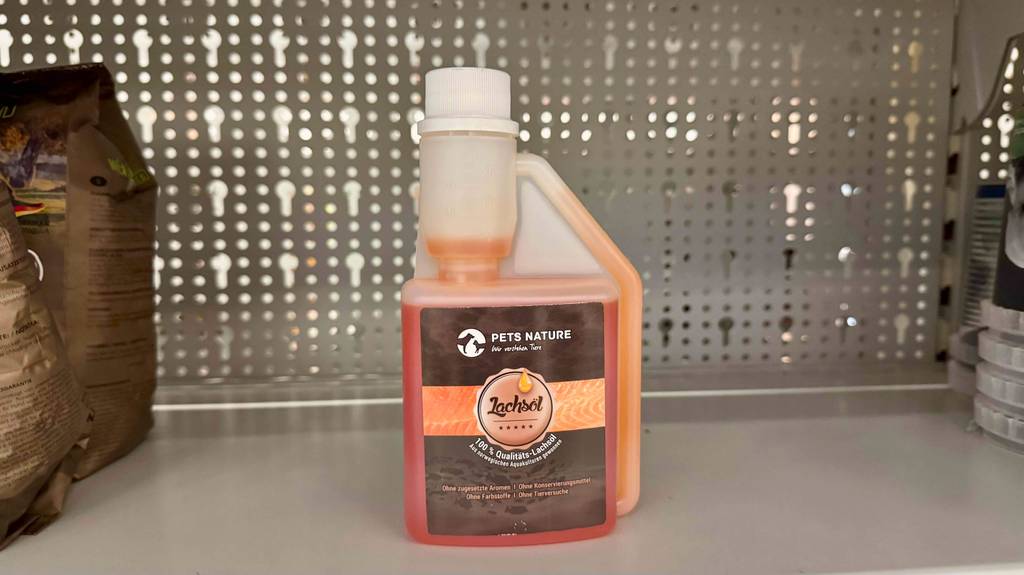 Getestetes Lachsöl für Hunde in der Kunststoffflasche mit Dosierkappe steht auf einem Verkaufsregal.