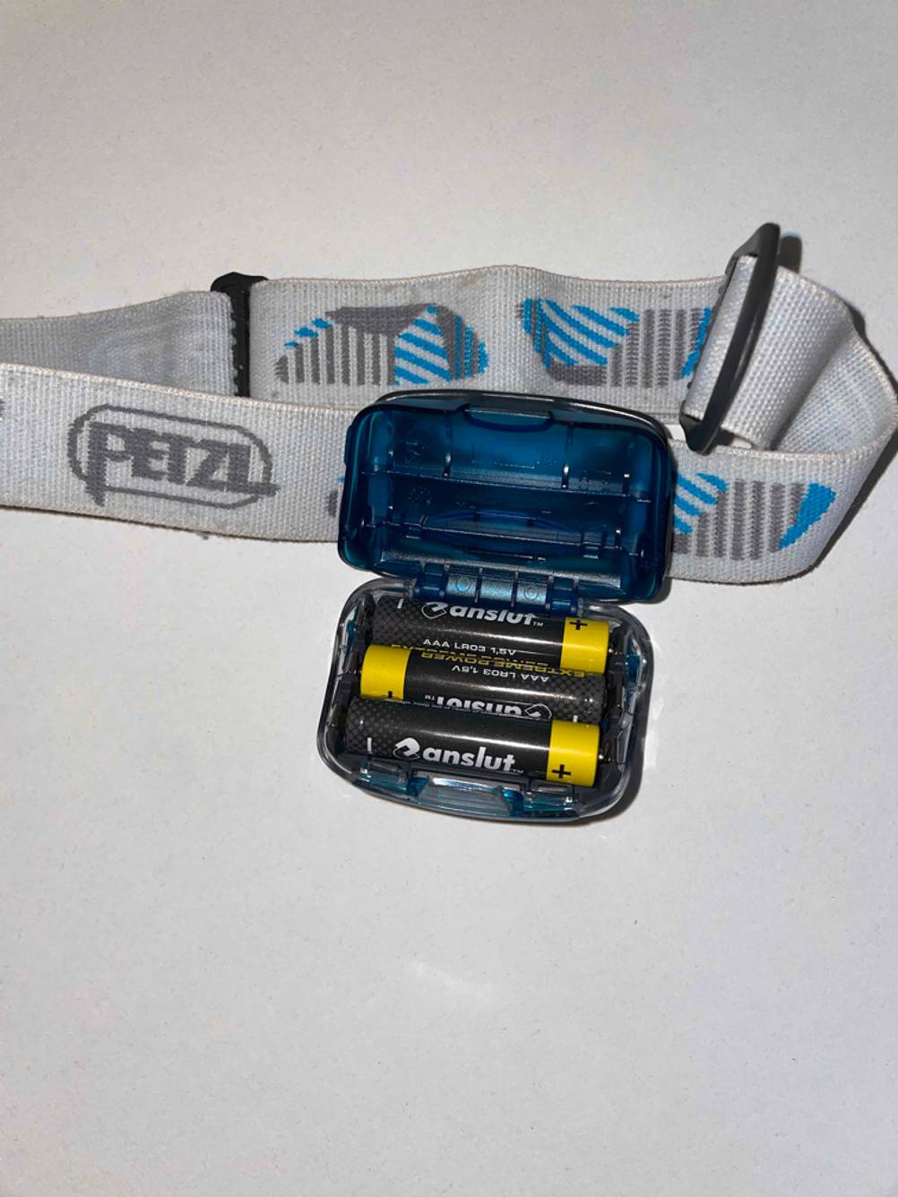 Eine getestete Petzl-Stirnlampe geöffnet mit Batterien im Inneren.