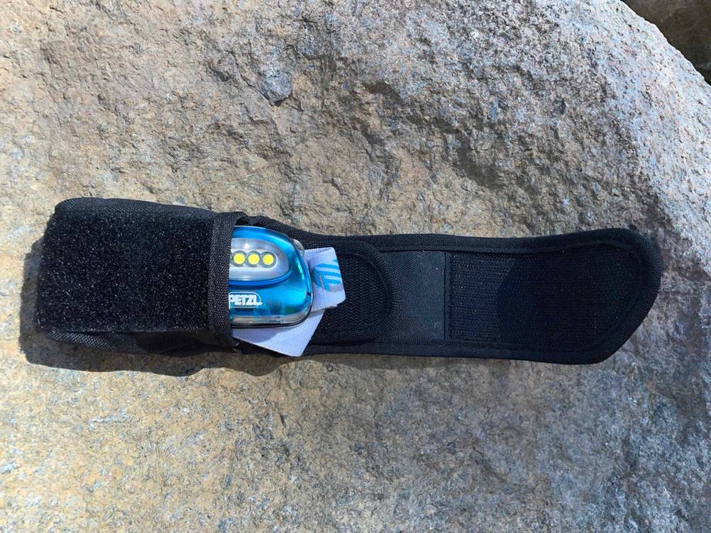 Petzl-Stirnlampen-Test: Aus ihrer Schutzverpackung schaut eine Petzl-Stirnlampe hervor.