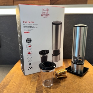 Verpackung, Pfeffermühle auf Standfuß, Batterien und Gefäß auf Holzplatte