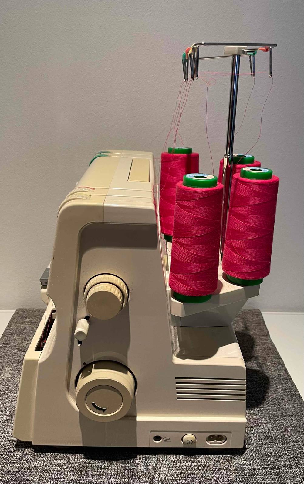 Seitenansicht einer Pfaff Hobbylock 4860 Coverlock im Test: auf der Maschine sind vier rote Garnrollen zu sehen.