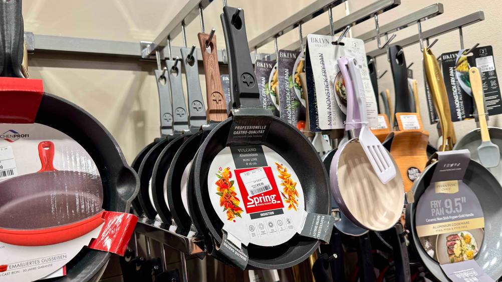 Pfanne 18 cm im Test: Mehrere Pfannen hängen in einem Laden.