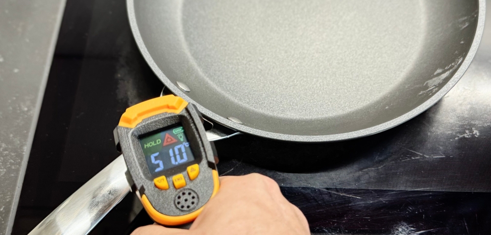 Pfannen-Test: Eine Person misst mit einem Laser-Thermometer die Temperatur des Stiels der Le-Creuset-Pfanne.