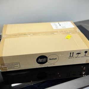 Die Verpackung der getesteten Pfanne von Tefal steht auf einem Kochfeld.