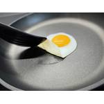 Eine Person hebt ein Spiegelei mit dem Pfannenwender in der getesteten Pfanne von Woll.