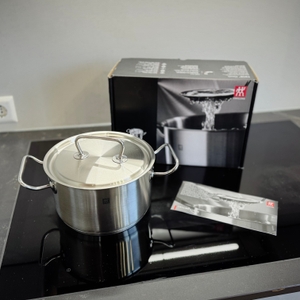 Der getestete Kochtopf von Zwilling steht zusammen mit der Verpackung auf einem Kochfeld.