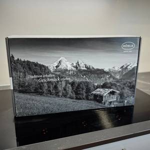 Die Verpackung des getesteten Rösle-Pfannensets steht auf einem Kochfeld.