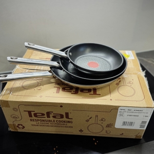 Die drei Pfannen des getesteten Pfannensets von Tefal stehen auf der Verpackung. 