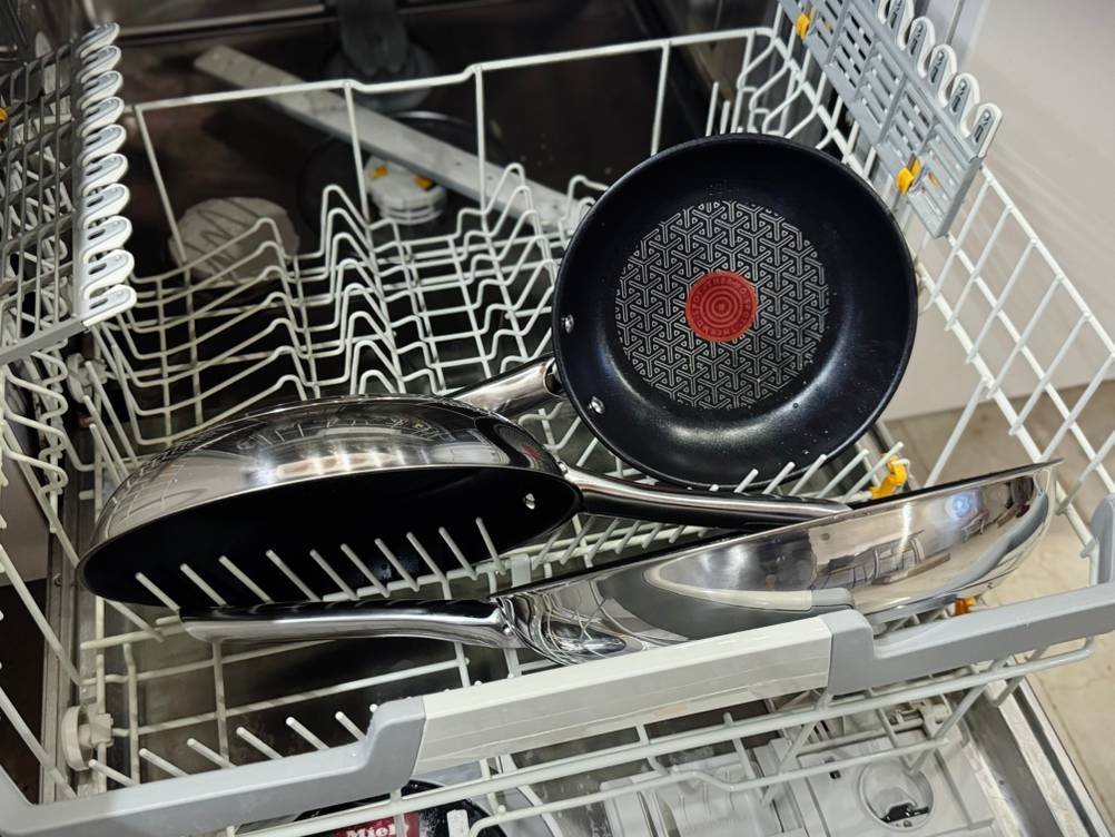 Drei Pfannen des getesteten Pfannensets von Tefal stehen in einer geöffneten Spülmaschine.
