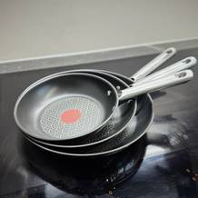 Das getestete Pfannenset von Tefal steht gestapelt auf einem Kochfeld.