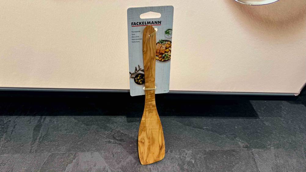 Getestet: Ein Pfannenwender Holz lehnt an einer hellen Wand.