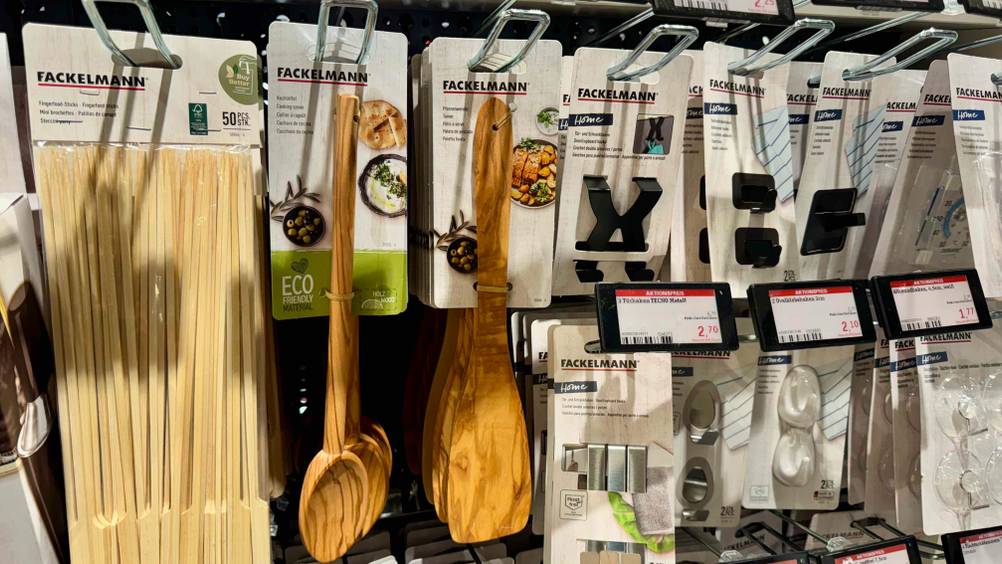 Mehrere Pfannenwender Holz im Test hängen in einem Verkaufsregal neben anderen Produkten.