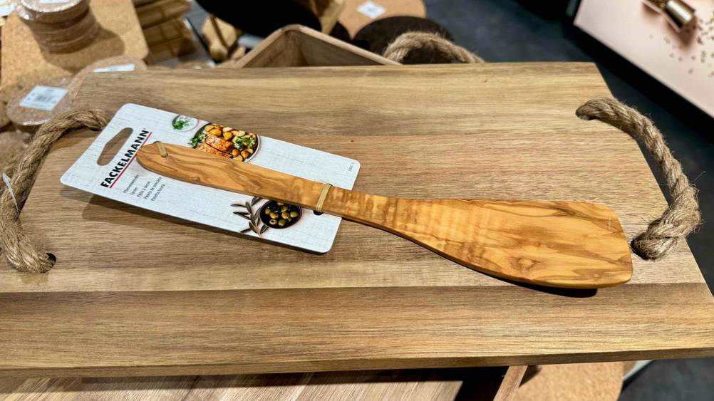 Auf einem Holzbrett liegt horizontal ein getesteter Pfannenwender Holz.