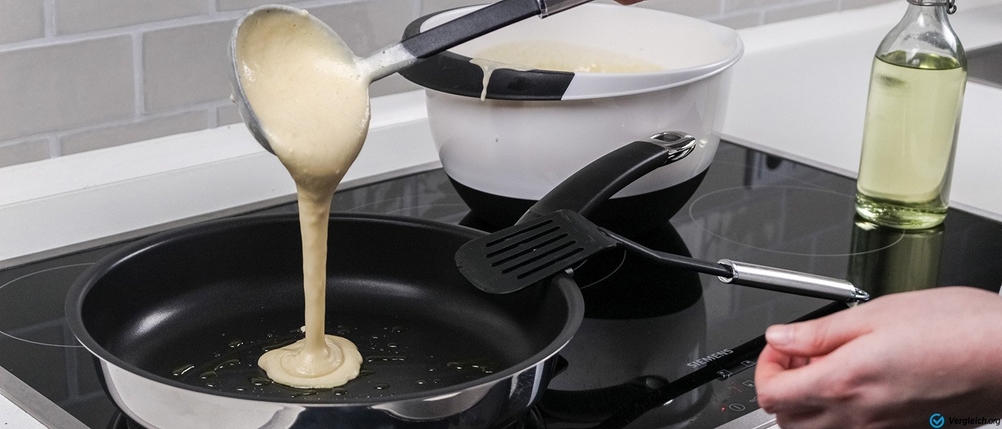 Pfannen-Test: Eine Person gießt Teig in eine Pfanne.