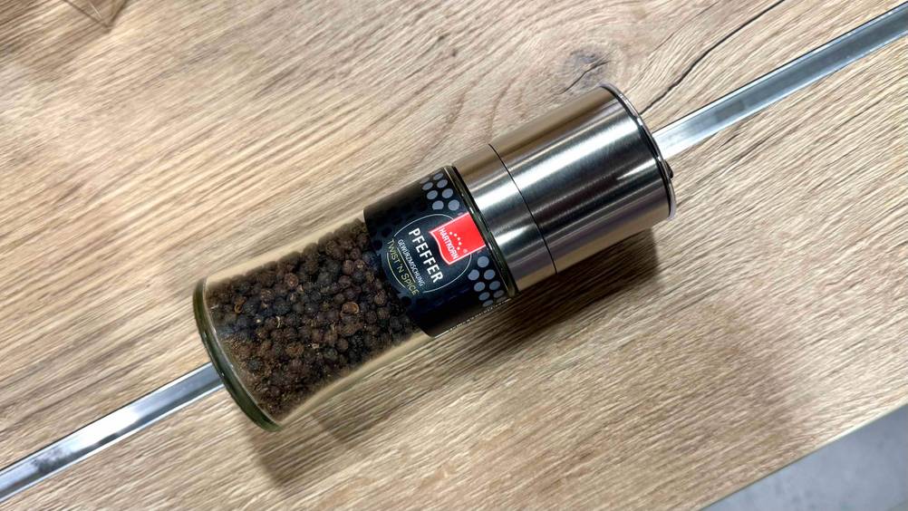 Eine Mühle des getesteten Pfeffers auf einer Holzfläche liegend.