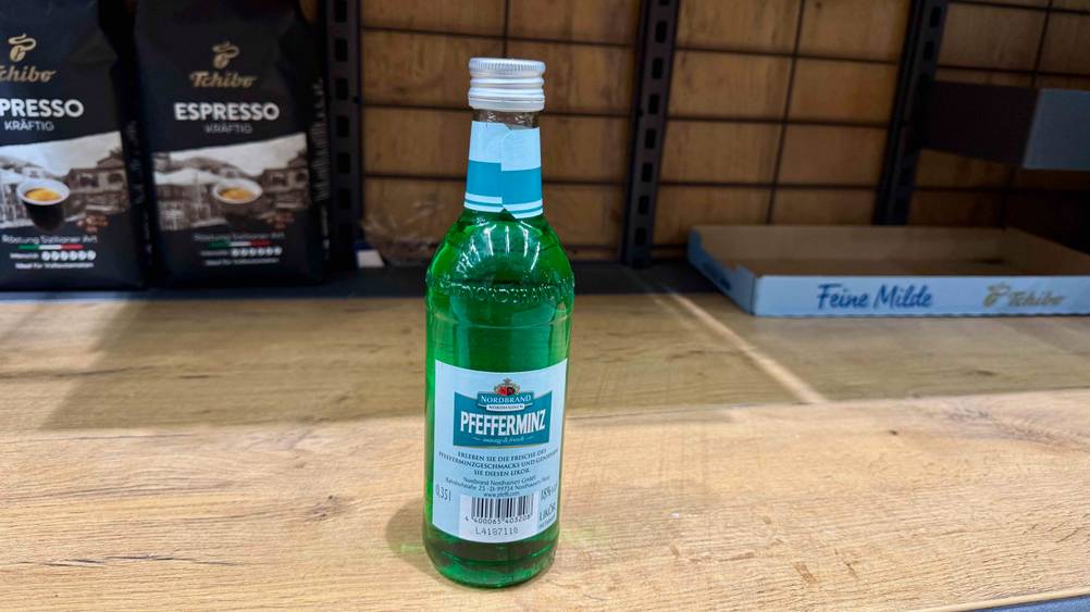 Rückseite einer Flasche des getesteten Pfefferminzlikörs auf einem Regal.