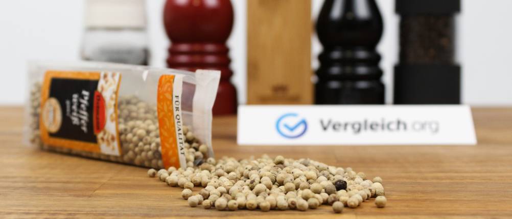 Pfeffermühlen-Test: ganze Pfefferkörner liegen ausgeschüttet auf einem Tisch