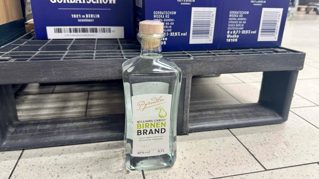 Im Test: Williams-Birnenbrand in der 700-ml-Flasche steht vor einem Verkaufsregal auf dem Boden.