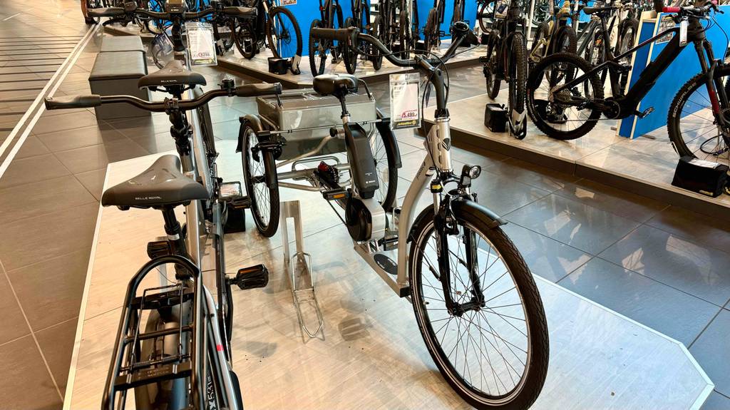 Im Test: Ein E-Bike-Dreirad von vorn betrachtet, wie es auf einem Ausstellungspodest im Verkaufsbereich steht.