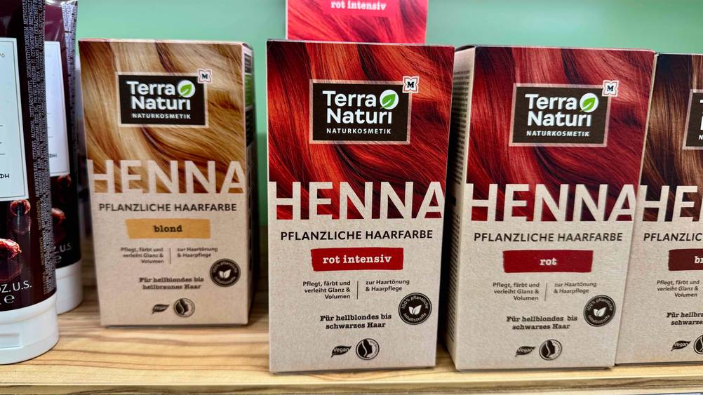 Mehrere Packungen der Pflanzenhaarfarbe im Test auf einem Regal.