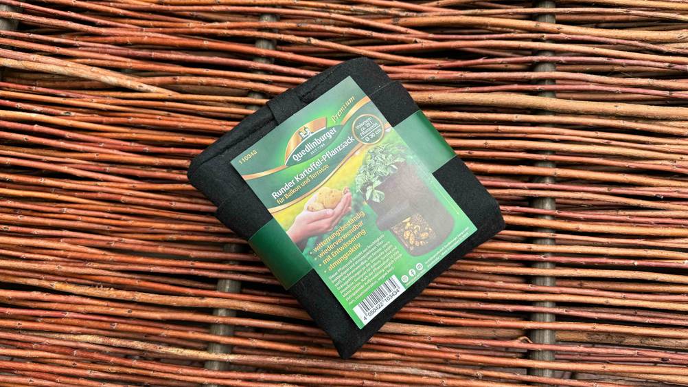 Getestet: Ein originalverpackter Pflanzsack von vorne auf einer Holzfläche.