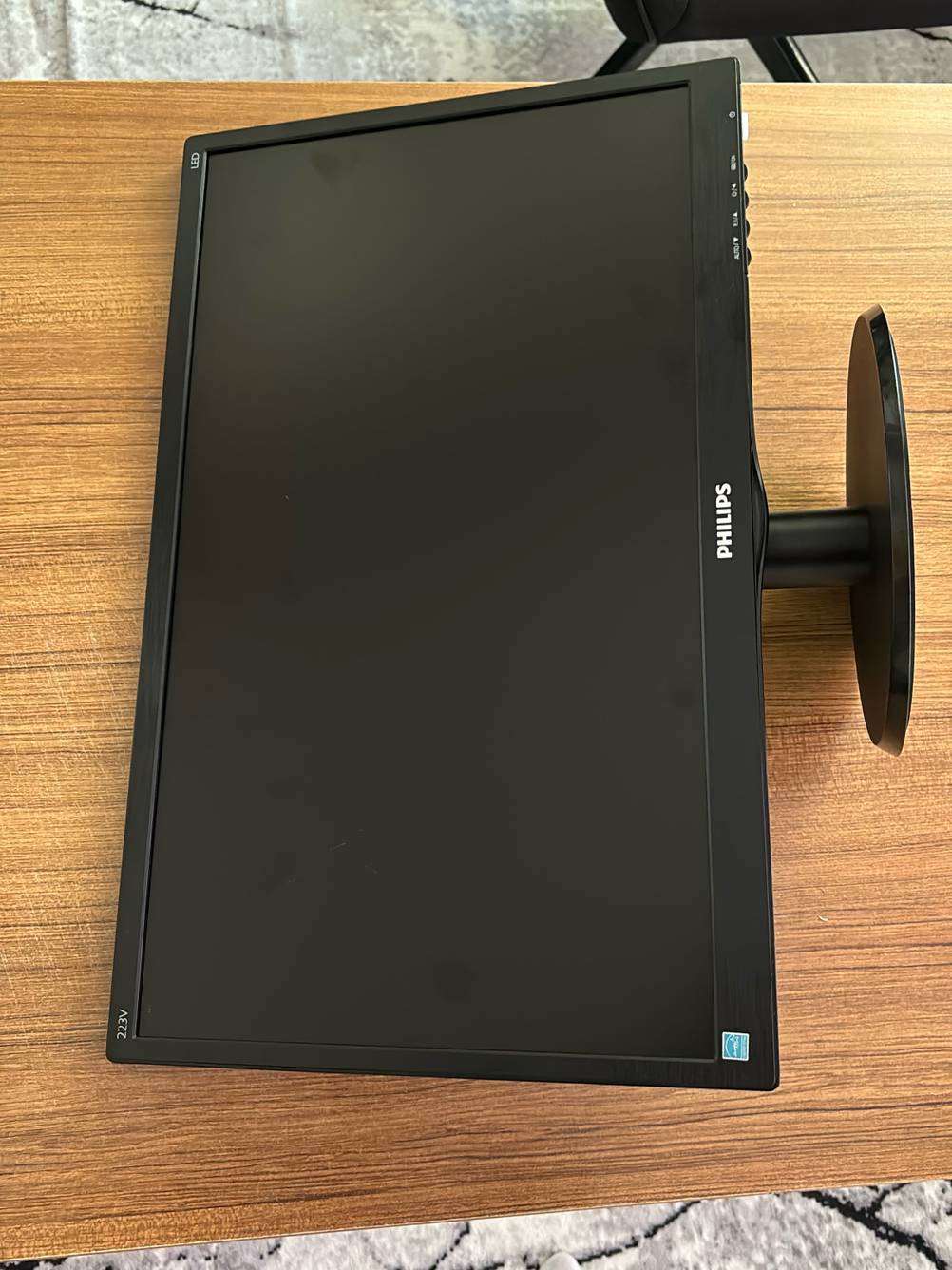 Ein getesteter 22-Zoll-Monitor liegt flach auf einem Holztisch.