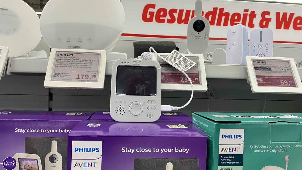 Babyphone getestet: Ein Gerät von vorne auf einer Verpackung stehend, dahinter Preisschilder.