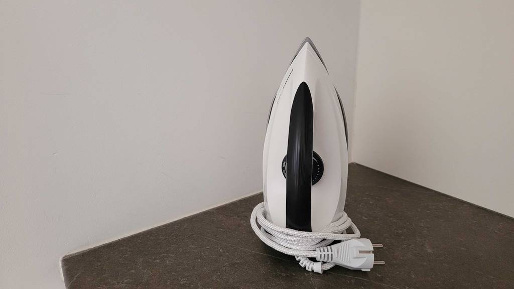 Getestet: Ein Philips Bügeleisen steht mit aufgewickeltem Stromkabel auf einem Tisch.