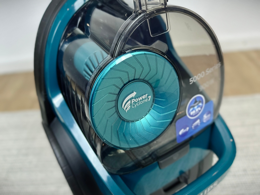 Der Philips FC9555/09 Staubsauger ist in Nahaufnahme zu sehen. Im Fokus steht der transparente Staubbehälter mit PowerCyclone 7-Technologie.