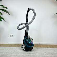 Der Philips FC9555/09 Staubsauger ist komplett aufgebaut zu sehen. Das Gerät steht aufrecht mit befestigtem Schlauch und Düse.