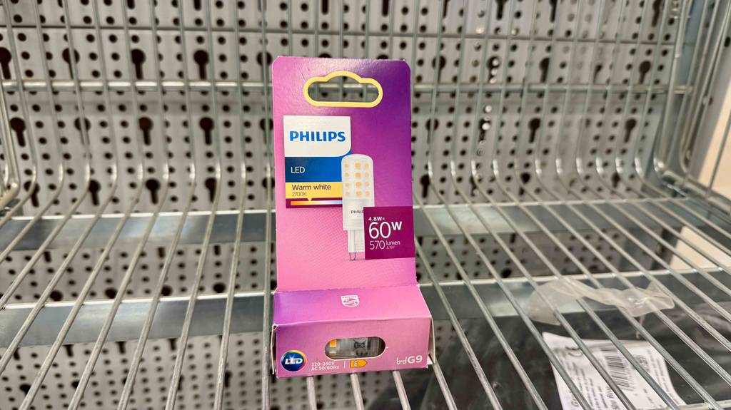 Ein original verpacktes dimmbares G9-LED im Test steht auf einem Reglabodengitter im Geschäft.