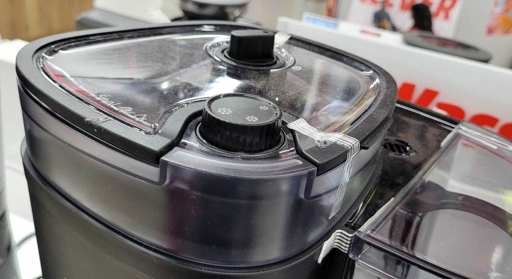 Detailaufnahme von oben auf den Deckel des Kaffeebohnenbehälters einer getesteten Kaffeemaschine mit Mahlwerk.