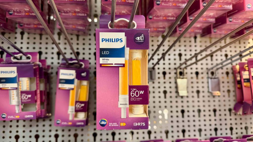 Ein pinke Verpackung mit einem getesteten dimmbaren R7S-LED (118mm) hängt vor weiteren Philips-LED-Lampen an einem Verkaufsstand.