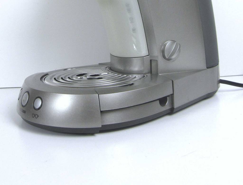 Test: Die Kaffeemaschine für Singles in Silbergrau mit Netzanschluss und Zwei-Tassen-Wahlschalter von seitlich vorn betrachtet.