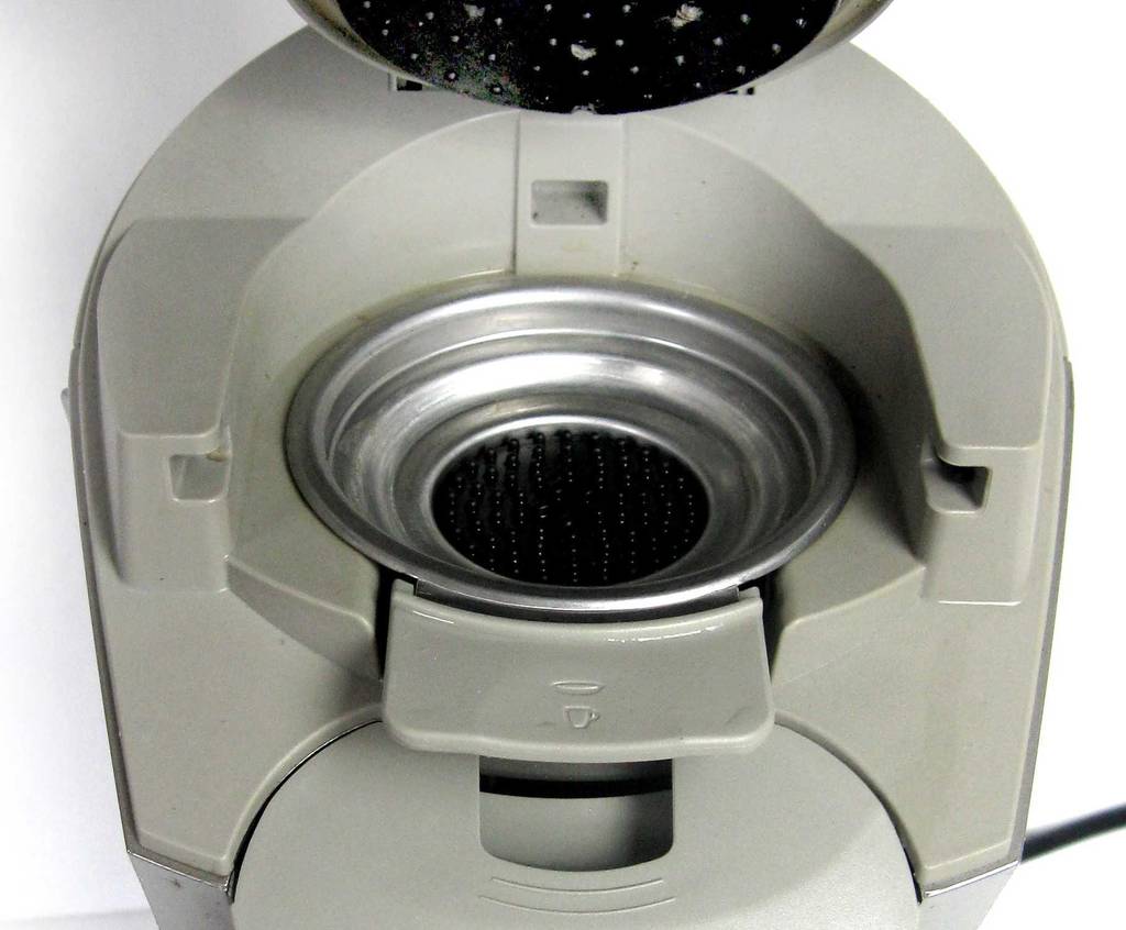 Detailansicht des Kaffeepad-Behälters im oberen Bereich der getesteten Kaffeemaschine für Singles in Silbergrau.