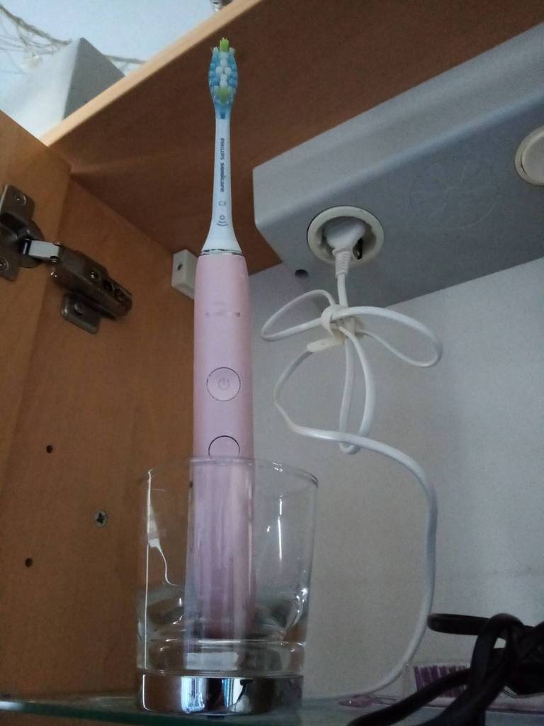 Eine rosa Sonicare Diamondclean Schallzahnbürste im Test steht in ihrem Glas zum Aufladen bereit.