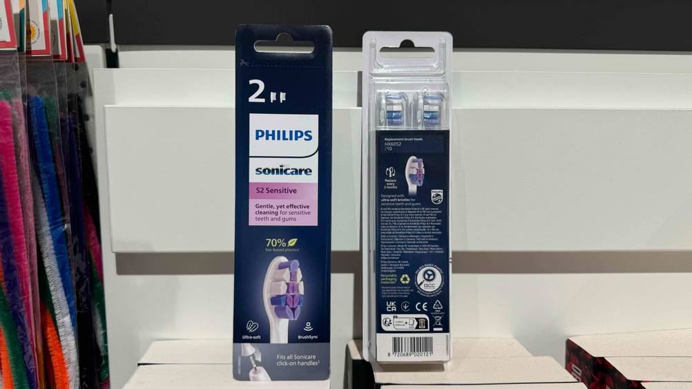 In einem Regal stehen zwei Packungen der Philips-Sonicare-Ersatzbürsten im Test, eine Packung von vorne eine von hinten.