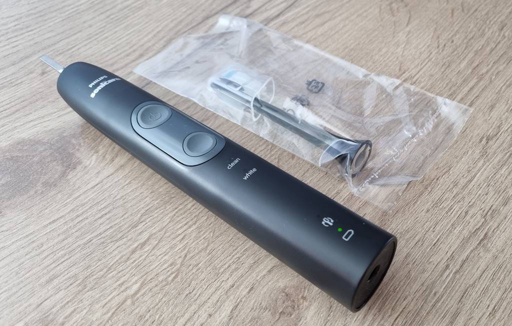 Eine getestete Philips Sonicare Zahnbürste liegt neben der Verpackung des Bürstenaufsatzes.