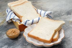 Philips-Toaster-Test: Toastbrotscheiben liegen auf einem weißen Teller und in einer Holz-Schale. 