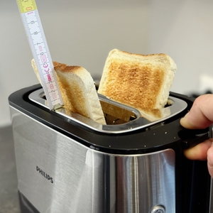 Toaster-Test: Das fertige Toast wird nach oben geschoben und mit einem Meterstab gemessen wir weit dieses aus dem Toaster steht.