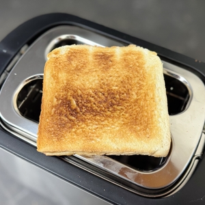 Auf dem getesteten Toaster von Philips liegt eine getoastete Scheibe Toastbrot.