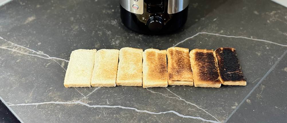 Toaster-Test: Vor dem getesteten Philips-Toaster liegen mehrere halbe Toastscheiben mit unterschiedlichen Bräunungsgraden.