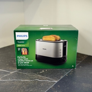 Der getestete Toaster von Philips steht verpackt auf einer dunklen Arbeitsfläche.